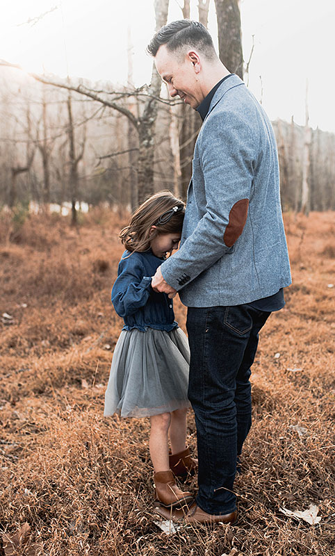 outdoor fall photo of father and young daughter who is standing on his feet